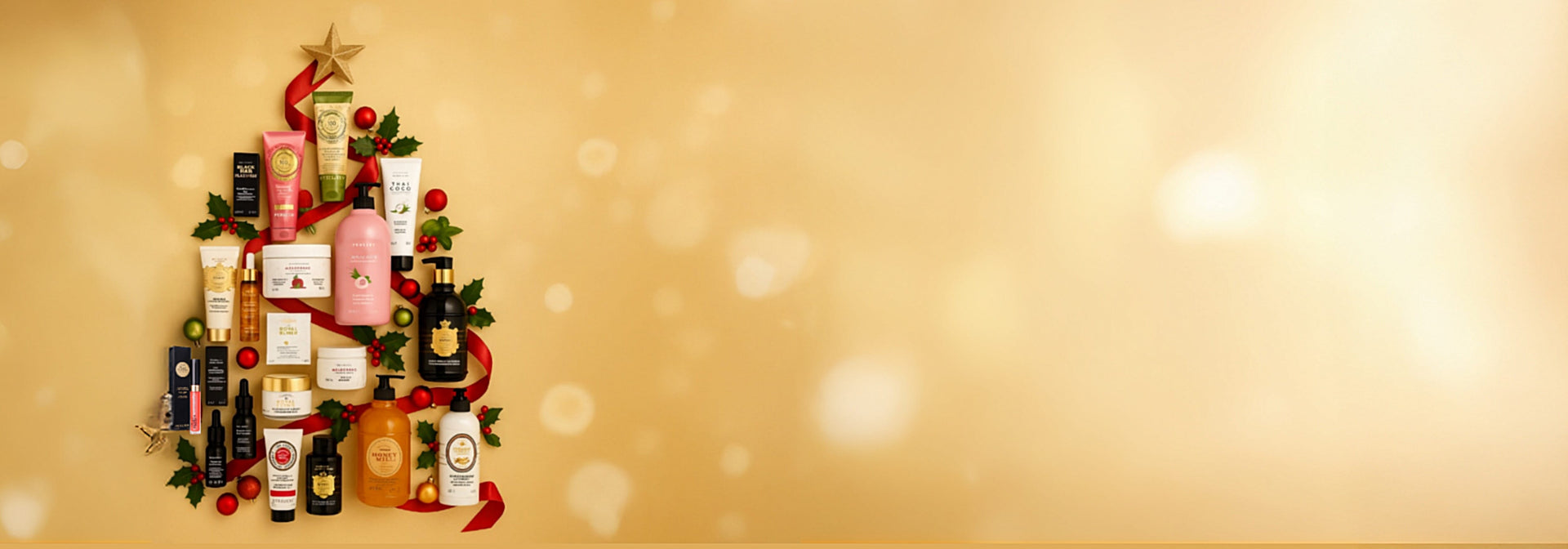 Various Perlier skincare products arranged in the shape of a christmas tree with holiday decorations on a gold backround