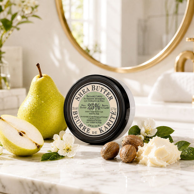6.7 oz jar of Perlier Shea Pear Body Balm on a marble vanity next to pears and shea nuts