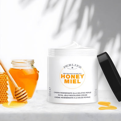 Perlier Honey Miel Revitalizing Body Cream with honey jar and honeycomb on a white background