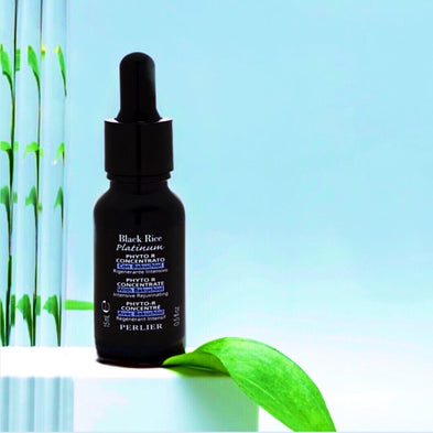 Perlier Black Rice Platinum Phyto-R concentrate bottle with dropper on a light blue background