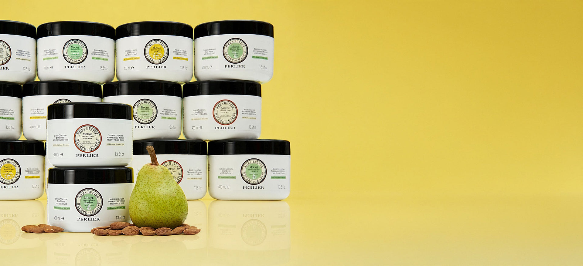 Assorted Perlier Shea Body Mousses on a yellow background