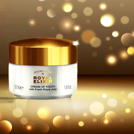 Perlier Royal Elixir Cream of Youth jar with gold lid on a blurred golden background