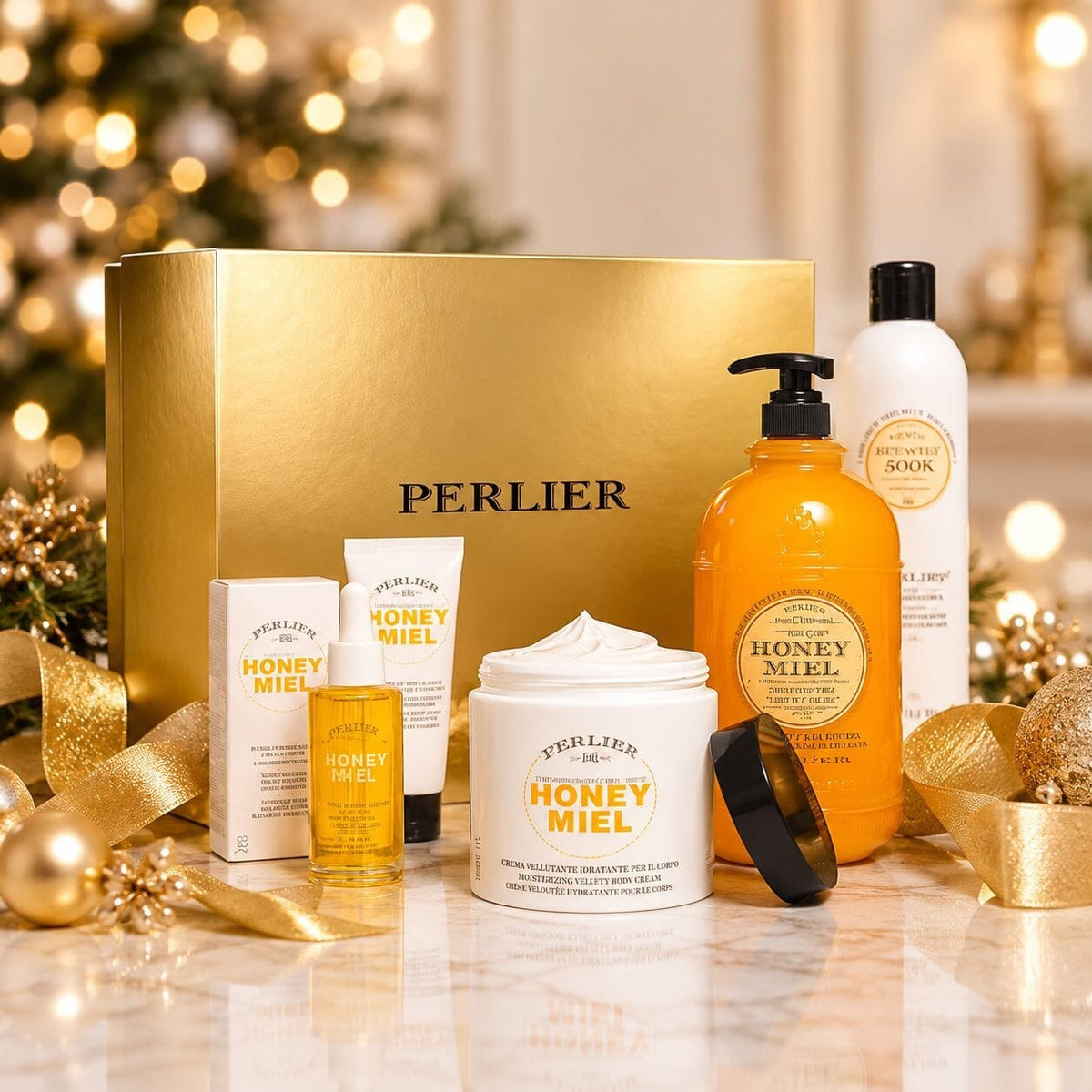 Perlier 5-pc Honey Miel gift set - body wash, hand cream, body oil, body cream and shampoo with gold gift box table in front of decorated holiday tree.