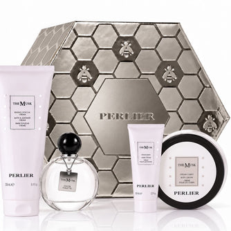 A holiday gift set from Perlier featuring The Musk products including a body wash, hand cream, body cream, and perfume arranged with a silver Perlier gift box, on a white background.