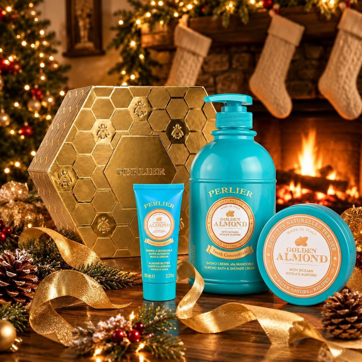 A Perlier Golden Almond gift set featuring a body wash, body balm, and hand cream, arranged on a table with gold ribbons, pinecones, and a warm fireplace background.