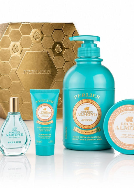 A Perlier Golden Almond gift set featuring a body wash, body balm, hand cream, and perfum, arranged in front of a gold hexagonal box on a white reflective surface.